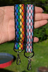 A rainbow and a trans Pride flag tablet woven key chain wristlet.