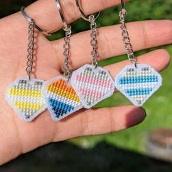 Demigender, aroace, demigirl and demiboy Pride flag key chains shaped like hearts.